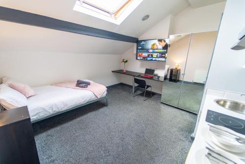 a bedroom with a bed and a desk and a television at 24 Dale Road Studios in Birmingham