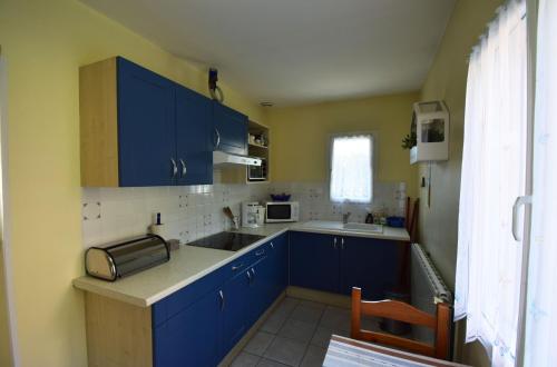 une cuisine avec des armoires bleues et un évier dans l'établissement Gîte Moncherie, à Colayrac-Saint-Cirq
