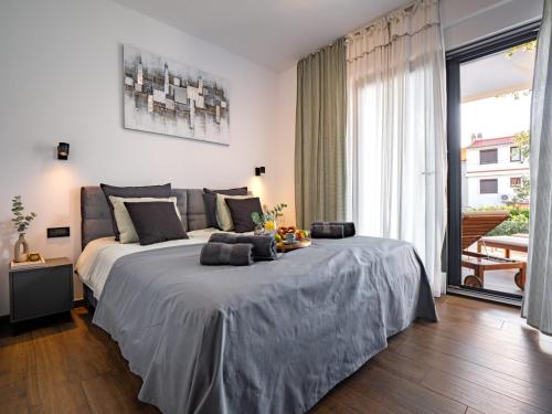 a bedroom with a large bed and a large window at Casa Dea in Malinska