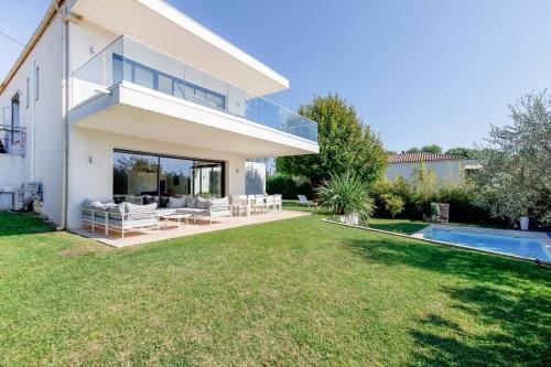 une maison blanche avec une cour et une piscine dans l'établissement Splendide villa contemporaine pour vos vacances de rêve à Mougins, à Mougins