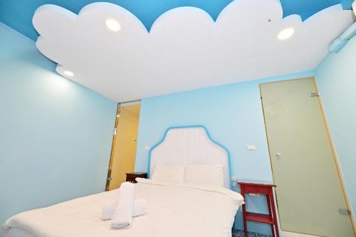 a bedroom with a bed with a cloud ceiling at 波斯卡朵親子城堡渡假民宿 in Magong