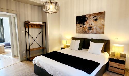 ein Schlafzimmer mit einem Bett und einem Gemälde an der Wand in der Unterkunft L'Atelier d'Antoine in Longeville-lès-Metz