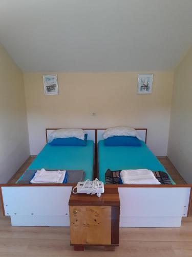 two beds in a room with two shoes on a table at Jenny`s House in Supetar