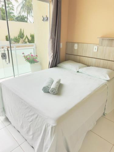 a bed with a pair of shoes sitting on it at Hotel Costa do Delta in Tutóia