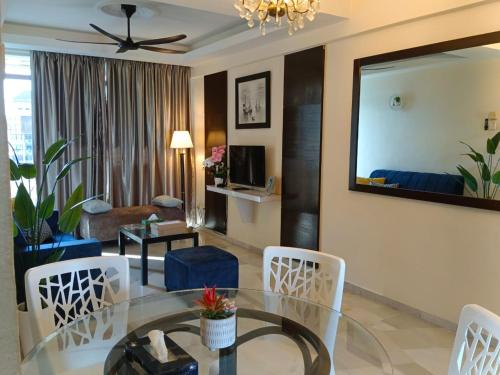 a living room with a glass table and chairs at Jev Penthouse in Port Dickson