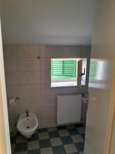 a bathroom with a toilet and a window at Jenny`s House in Supetar