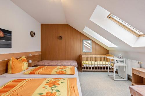 1 dormitorio en el ático con 2 camas y 1 cuna en Ferienwohnung Ufert, en Meißen