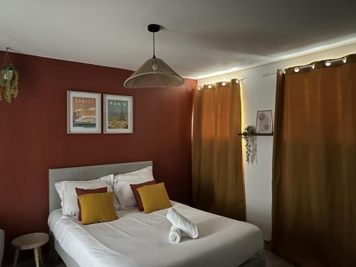 - une chambre avec un lit doté d'oreillers jaunes et blancs dans l'établissement La Place, à Calais