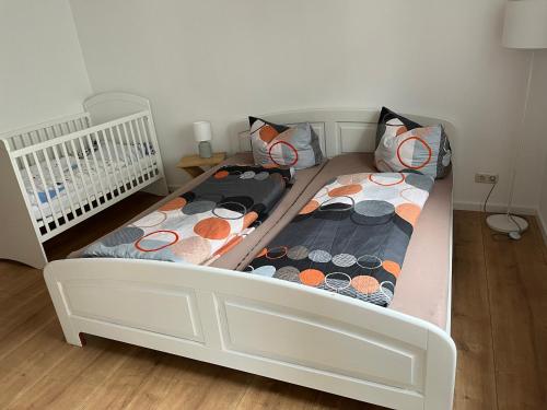two twin beds in a small room with a crib at Superschöne 4-Zimmerwohnung in Hallstadt