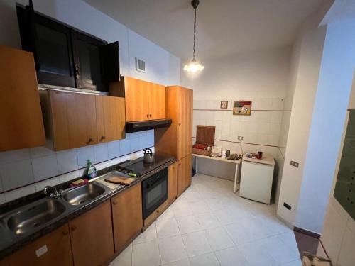 a kitchen with wooden cabinets and a sink and a refrigerator at Azienda agricola zootecnica Soriente di Guglielmo Areh Soriente & C.S.A.S in Roccapiemonte
