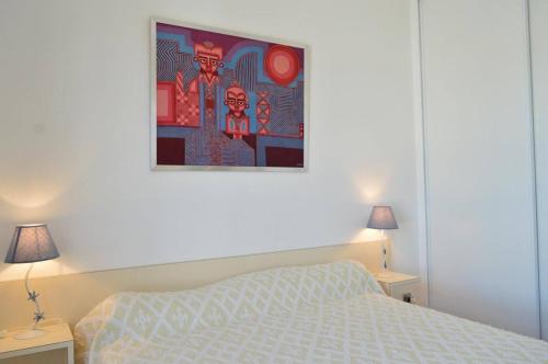 une chambre avec un lit et un tableau au mur dans l'établissement 2 pièces belle vue mer CAP D 'AGDE CT360-435, au Cap d'Agde
