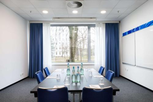 a conference room with a long table and blue chairs at Park Inn by Radisson Frankfurt Airport in Frankfurt/Main