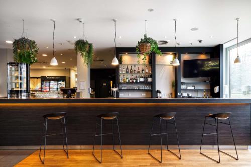 a bar in a restaurant with stools at Park Inn by Radisson Frankfurt Airport in Frankfurt/Main
