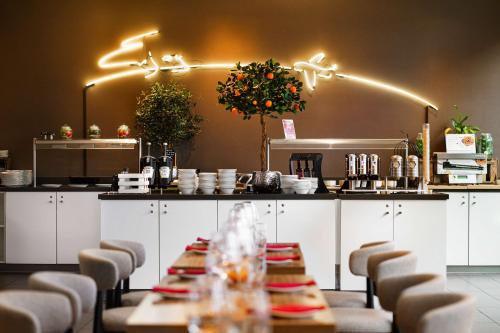 a dining room with a table and chairs and a kitchen at Park Inn by Radisson Frankfurt Airport in Frankfurt/Main