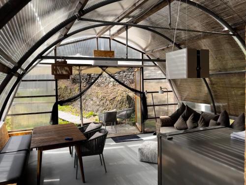 a room with a table and chairs in a greenhouse at Agriturismo Voeuja Lago Maggiore in Luino