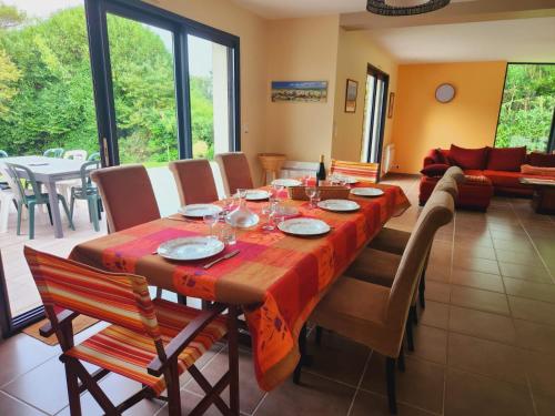 une salle à manger avec une table et des chaises dans l'établissement Jolie maison de vacances avec une vue magnifique sur le jardin, à Combrit