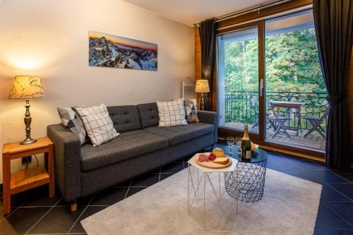 un salon avec un canapé et une table dans l'établissement Le Paradis 15 Apartment - Chamonix All Year, à Chamonix-Mont-Blanc
