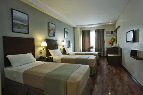 um quarto de hotel com duas camas e uma televisão em Fersal Hotel Kalayaan, Quezon City em Manila