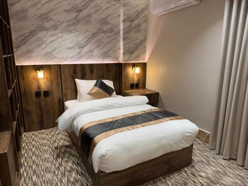 a bedroom with a large bed with a painting on the wall at Medad Apartments Al Hamra in Al Khobar