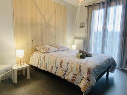 un dormitorio con una cama y una ventana en Le SENS UNIQUE, en Rodez