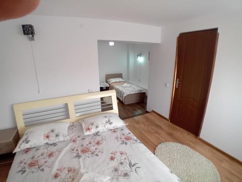 a bedroom with a bed with flowers on it at Pensiunea Dimitrie in Mănăstirea Humorului