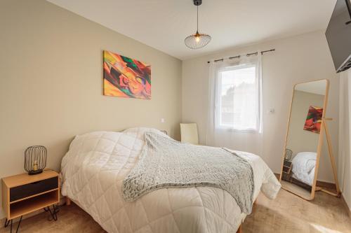 a bedroom with a bed and a mirror at Villa Kaino 1 - Climatisée avec jardin in Ondres