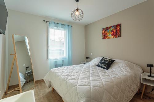 a bedroom with a white bed and a mirror at Villa Kaino 2 - Climatisée avec piscine in Ondres