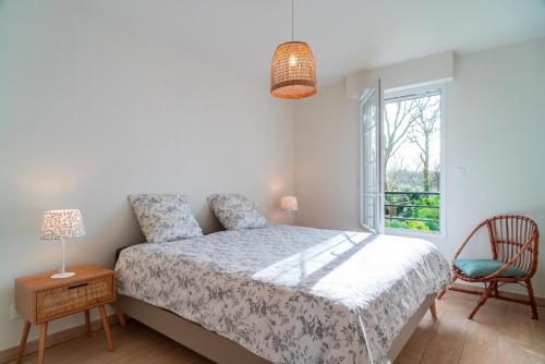 une chambre avec un lit, une fenêtre et une chaise dans l'établissement La Cale de Beg Meil - 100m de la plage, à Fouesnant