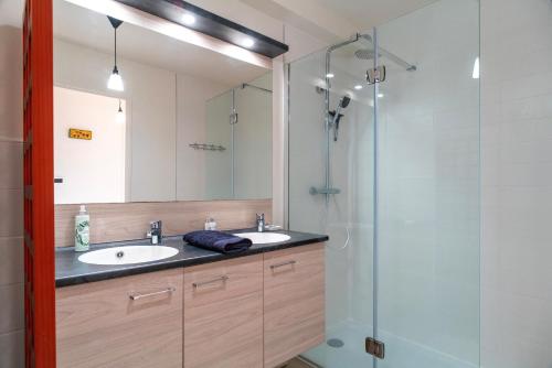 une salle de bain avec deux lavabos et une douche en verre dans l'établissement La Cale de Beg Meil - 100m de la plage, à Fouesnant