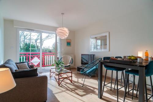 un salon avec un canapé et une table dans l'établissement La Cale de Beg Meil - 100m de la plage, à Fouesnant