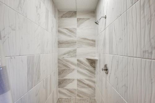 a bathroom with a shower with white marble tiles at 8 Mi to Kentucky Downs Quiet Getaway with Patio in Portland
