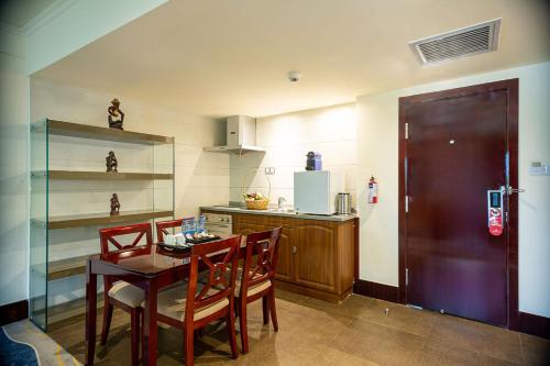 a kitchen with a table and chairs and a counter at Lancaster Kumasi City in Kumasi