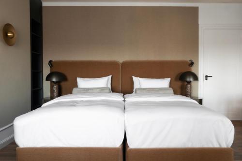 two beds sitting next to each other in a bedroom at Park Lane Copenhagen in Hellerup