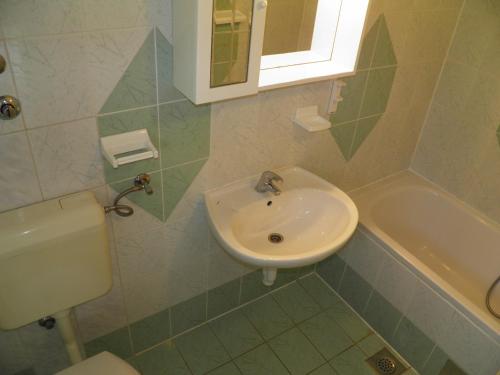 a bathroom with a sink and a toilet at Apartments Miljenka in Baška