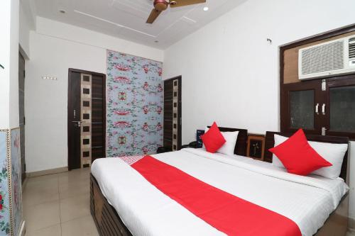 a bedroom with a large bed with red pillows at Four Seasons in Sikandra