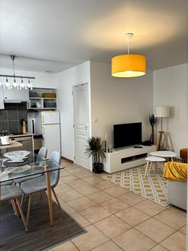 Il comprend un salon avec une table à manger et une cuisine. dans l'établissement Cozy atmosphere 4pers near Eurexpo GroupamaStadium, à Saint-Priest