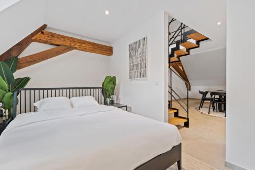 a bedroom with a white bed and a staircase at Modern Apartments in Clausen with WiFi, Kitchen & Workspace in Luxembourg
