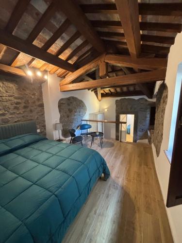 a bedroom with a blue bed in a room with stone walls at Casa Marí in Montefiascone