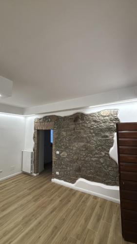 a living room with a stone wall and a fireplace at Casa Marí in Montefiascone