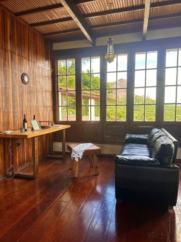 a living room with a couch and a desk at Sitio mirante do Lopo in Vargem