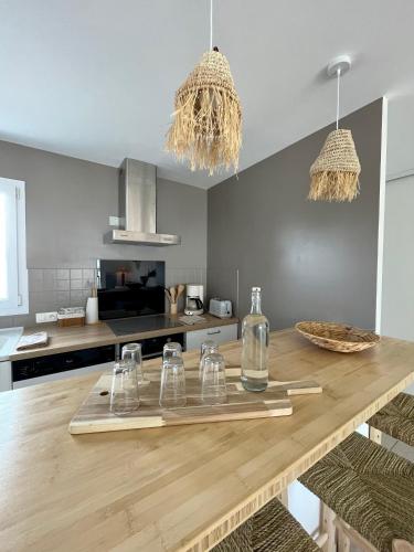 - une cuisine avec une table en bois et des verres dans l'établissement Coco Sardine, à Saint-Gilles-Croix-de-Vie