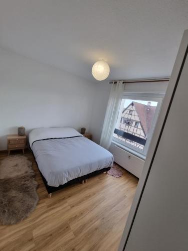 une chambre avec un lit et une fenêtre dans l'établissement Les toits de Colmar - Parking, à Colmar