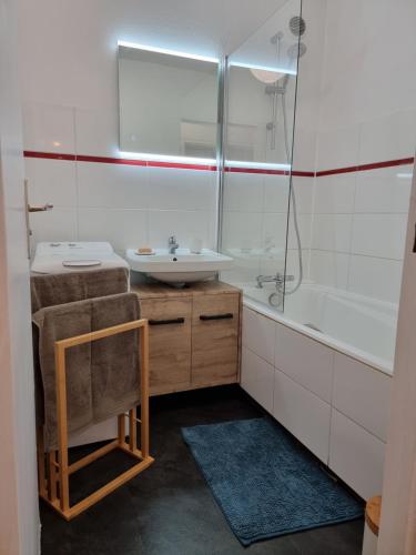 une salle de bain blanche avec un lavabo et une douche dans l'établissement Les toits de Colmar - Parking, à Colmar