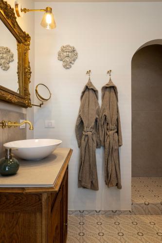 a bathroom with a sink and towels hanging on the wall at B&B l'Inconnu in Roeselare
