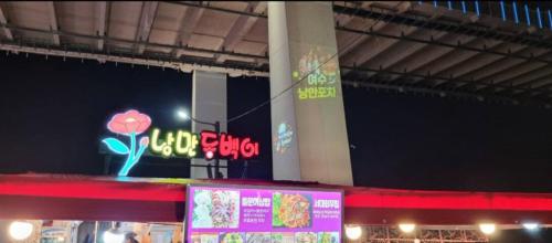 a store with a neon sign in a building at Yeosu UTOP UBLESS All Rooms Stunning Ocean View in Yeosu
