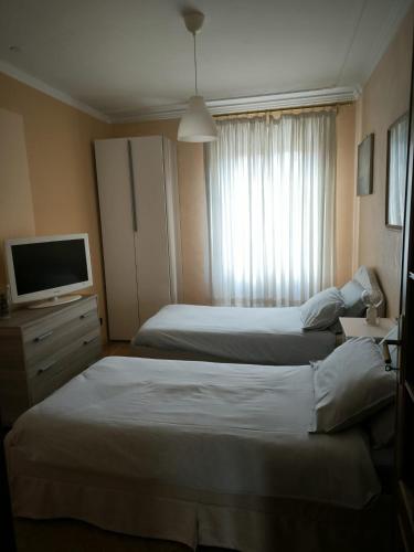 a hotel room with two beds and a television at Residenza Vernato in Biella
