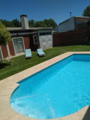 una grande piscina blu con due sedie accanto a una casa di Mic-Bau a Villa Elisa