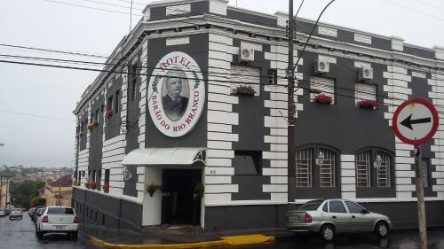 a black and white building with a sign on it at Hotel Barão Do Rio Branco in Bebedouro