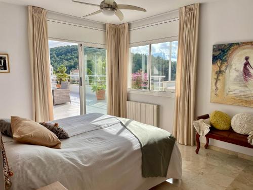 Un dormitorio con una cama y una ventana grande. en Entire villa with pool, ocean & mountain views, en Sitges