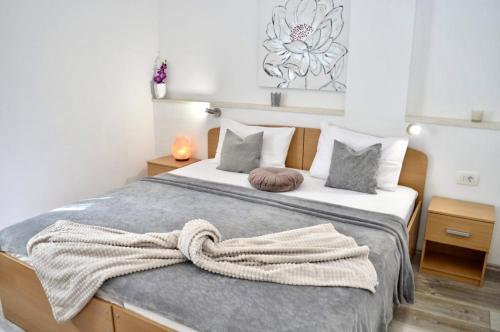 a bedroom with a bed with a blanket on it at Apartments Karla in Stanići